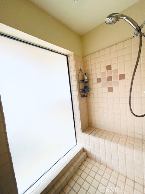 bathroom with tile patterned floors and a tile shower