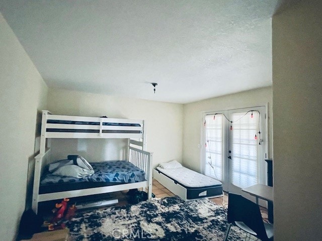 bedroom with french doors and hardwood / wood-style floors