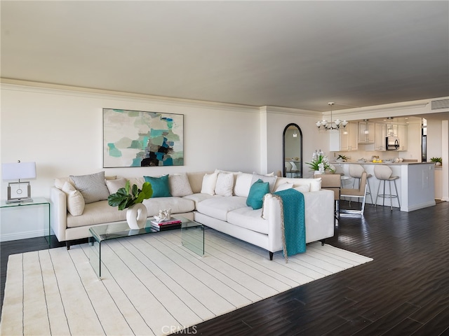 living room featuring crown molding, hardwood / wood-style flooring, and a chandelier