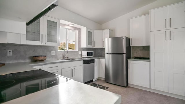 kitchen featuring white cabinetry, stainless steel appliances, and vaulted ceiling