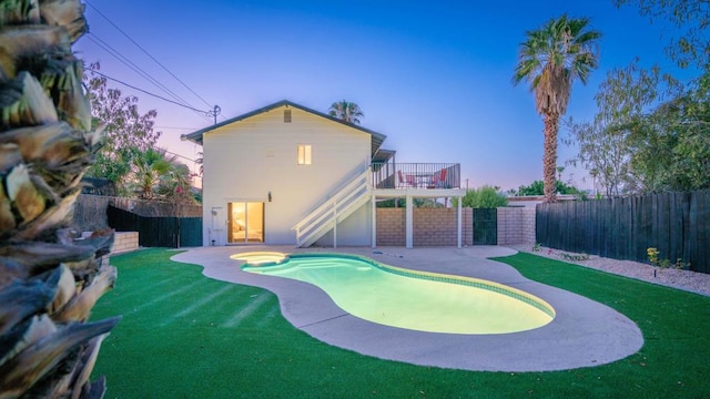 pool at dusk with a yard and a patio area