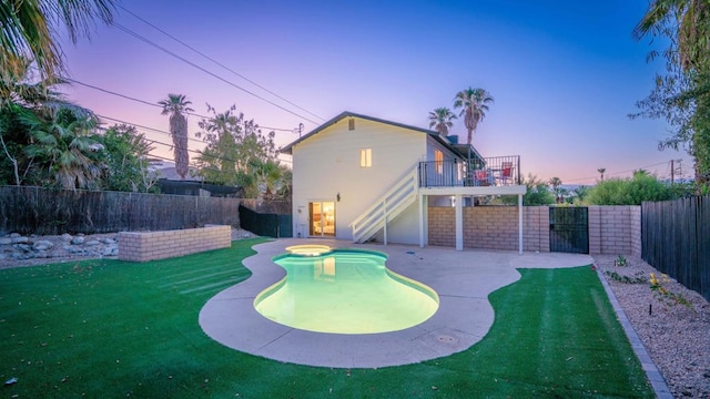 pool at dusk with a yard and a patio