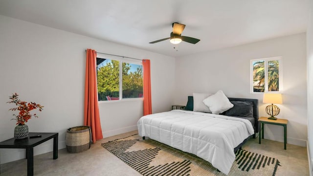 bedroom featuring ceiling fan, light colored carpet, and multiple windows