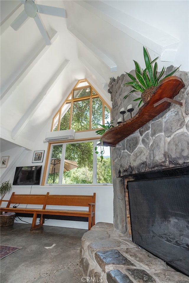 living room with vaulted ceiling with beams, a stone fireplace, and ceiling fan