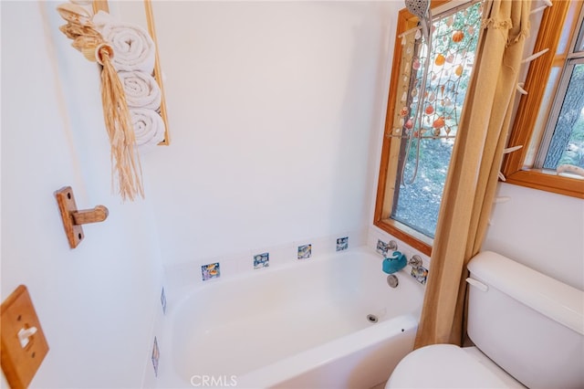 bathroom featuring toilet and a tub to relax in