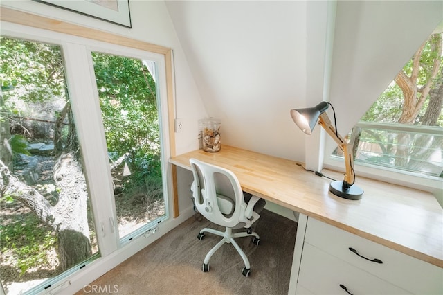 office featuring built in desk, light colored carpet, and a wealth of natural light