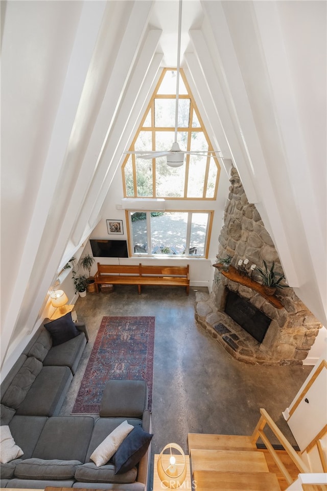 living room with a stone fireplace, beam ceiling, and high vaulted ceiling