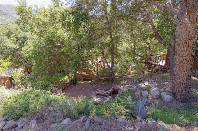 view of yard featuring a deck with mountain view