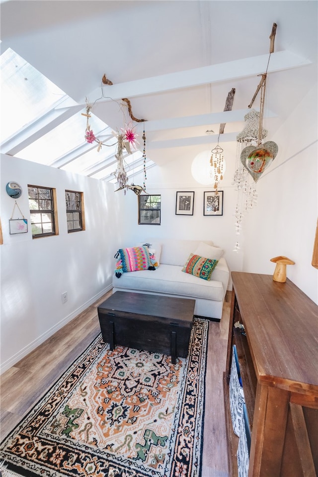 bedroom with wood-type flooring and vaulted ceiling with beams