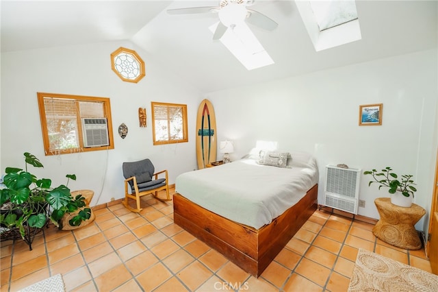 bedroom featuring lofted ceiling with skylight, heating unit, light tile patterned floors, and ceiling fan