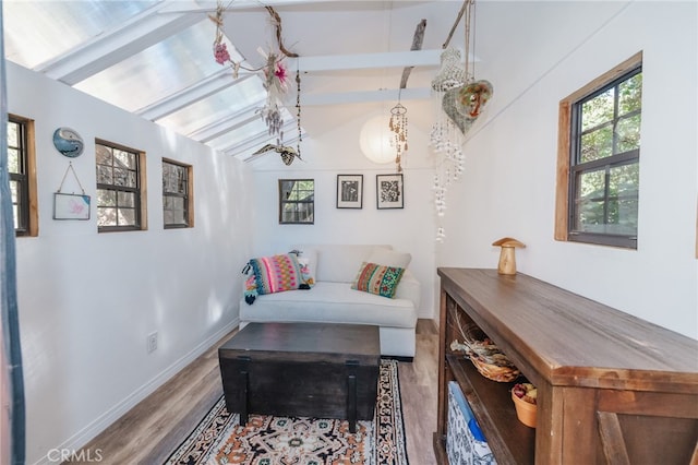 living room featuring vaulted ceiling with beams and hardwood / wood-style floors