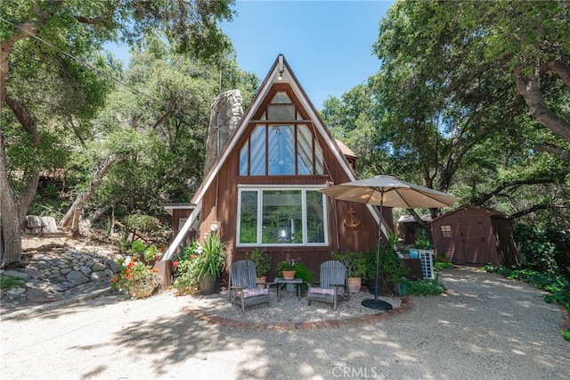 rear view of property featuring a shed