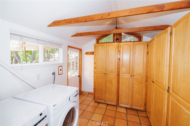 washroom featuring light tile patterned flooring, cabinets, and washer and clothes dryer