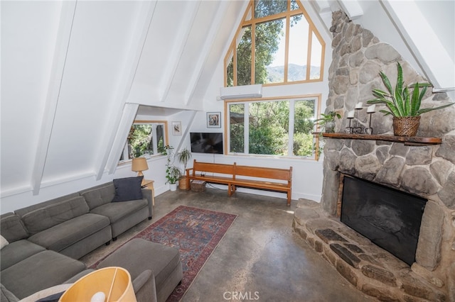 living room featuring concrete floors, a healthy amount of sunlight, beam ceiling, and a fireplace