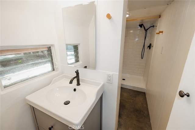 bathroom with vanity and a tile shower