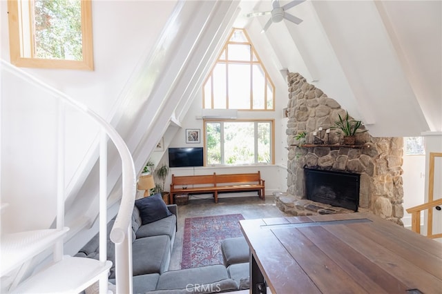 living room with ceiling fan, high vaulted ceiling, and a fireplace