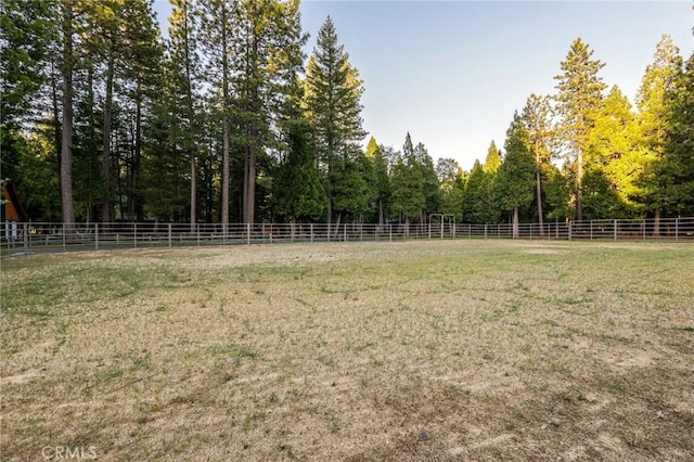 view of yard with fence and a rural view