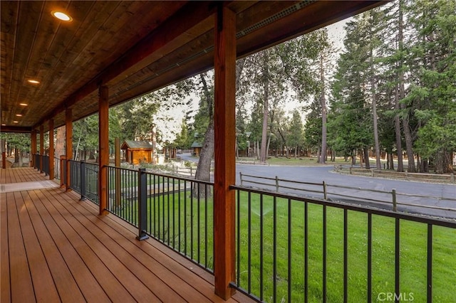 wooden terrace with a lawn and fence