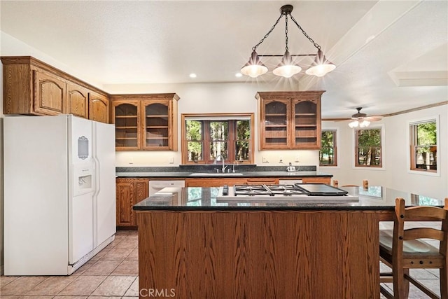 kitchen featuring glass insert cabinets, dark countertops, and white appliances