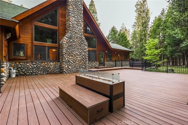 wooden deck featuring an outdoor fire pit and fence