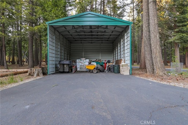 view of outbuilding with aphalt driveway and a detached carport