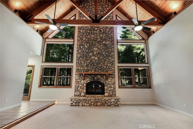 unfurnished living room featuring a stone fireplace, wood ceiling, carpet flooring, and high vaulted ceiling