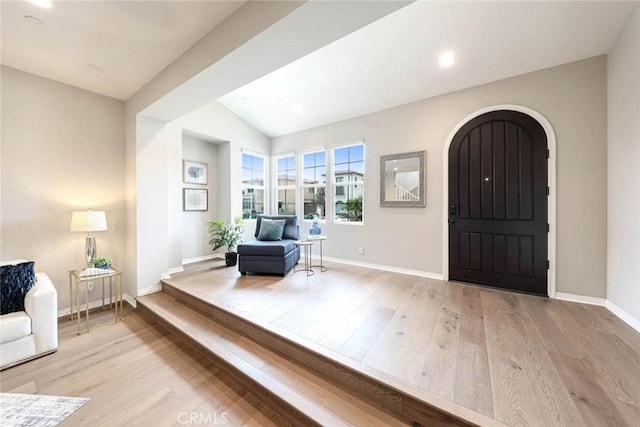 entrance foyer featuring light hardwood / wood-style floors and vaulted ceiling