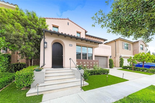 mediterranean / spanish-style house featuring a garage and a front lawn