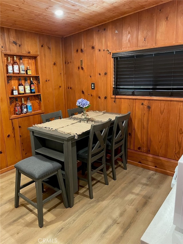 dining space featuring light hardwood / wood-style flooring and wood ceiling