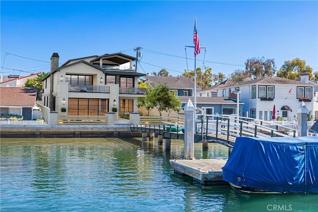 dock area featuring a water view, a balcony, and a residential view