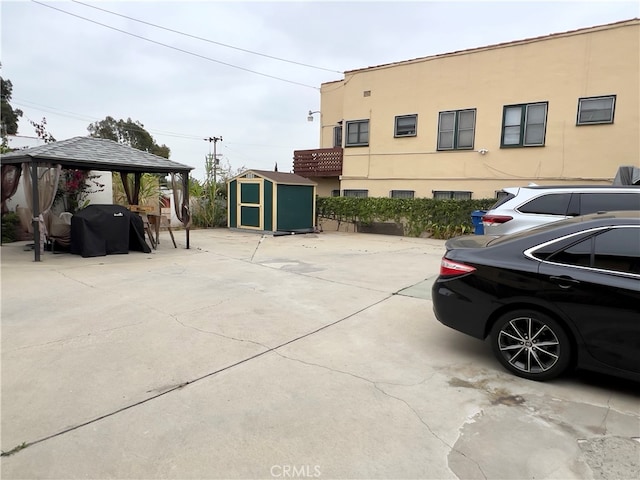 view of patio with a gazebo, area for grilling, and a shed