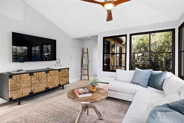 living room with ceiling fan, wood-type flooring, and vaulted ceiling