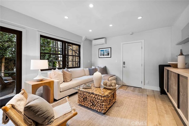 living room featuring a wall mounted AC and light hardwood / wood-style floors