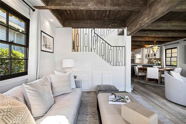 living room with wooden ceiling, hardwood / wood-style floors, beamed ceiling, and an inviting chandelier