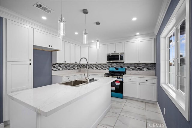 kitchen featuring pendant lighting, white cabinets, sink, light stone counters, and stainless steel appliances