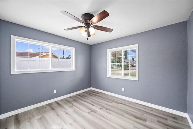 unfurnished room with ceiling fan, a healthy amount of sunlight, and light wood-type flooring