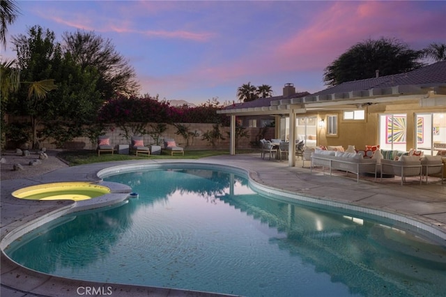 pool at dusk featuring a patio area and outdoor lounge area