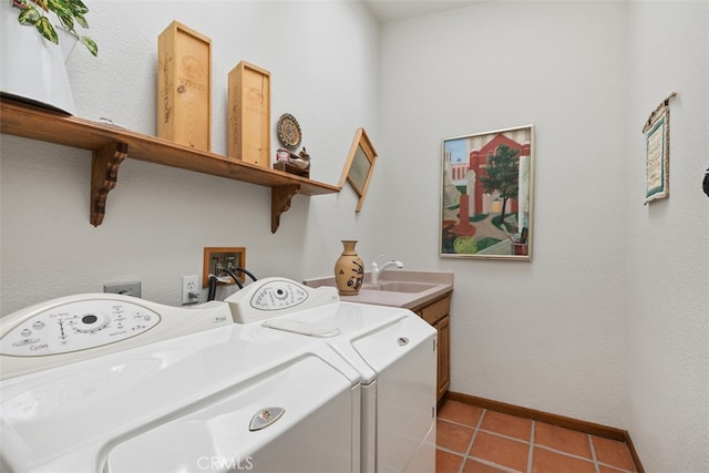 laundry area featuring sink, light tile patterned flooring, cabinets, and washing machine and clothes dryer