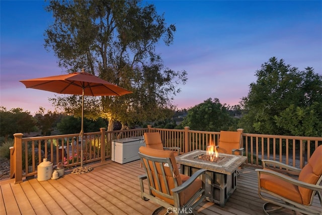 deck at dusk featuring a fire pit