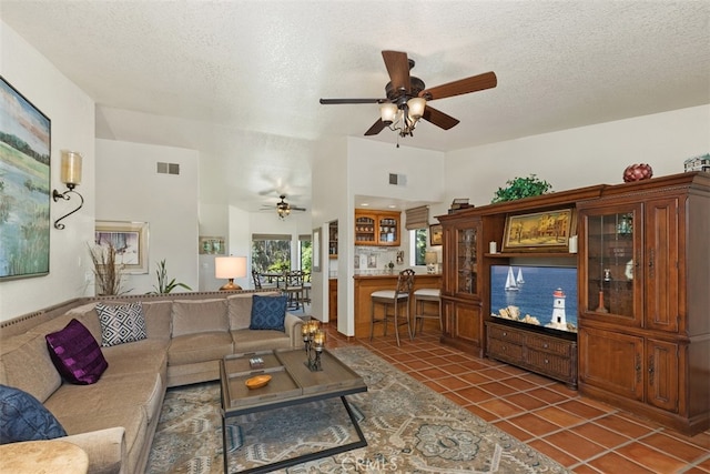 tiled living room with a textured ceiling and ceiling fan