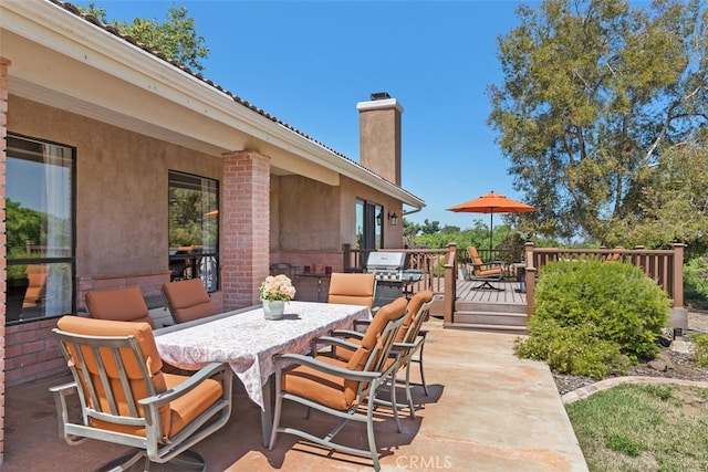 view of patio featuring a wooden deck and a grill