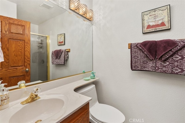 bathroom featuring vanity, toilet, and a shower with door