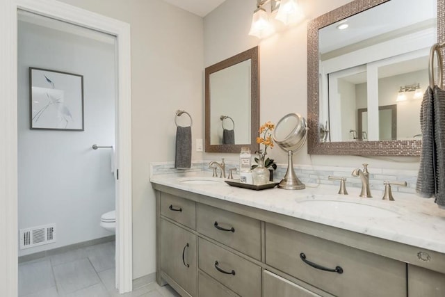 bathroom with vanity, toilet, and tile patterned floors