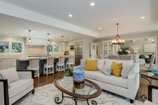 living room featuring dark wood-type flooring and an inviting chandelier