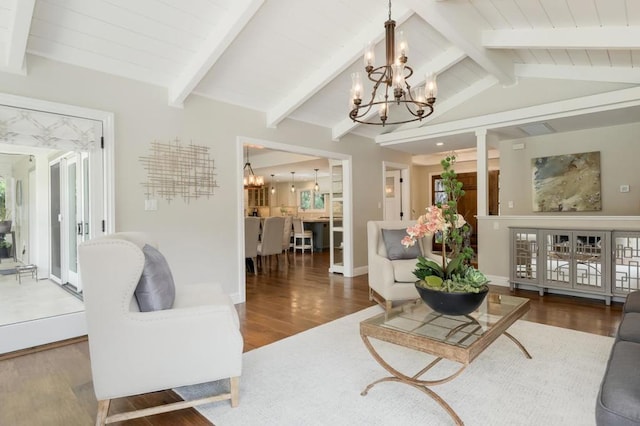 living room with a notable chandelier, lofted ceiling with beams, and dark hardwood / wood-style floors