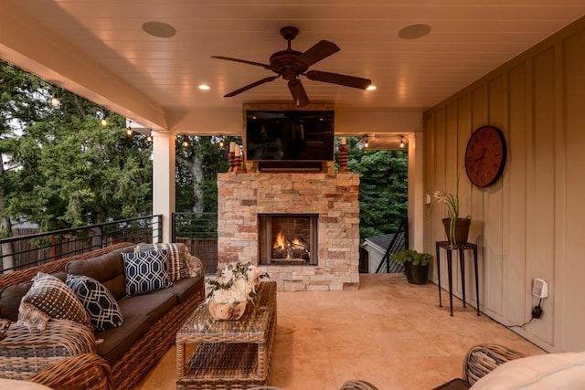 view of patio with an outdoor living space with a fireplace and ceiling fan