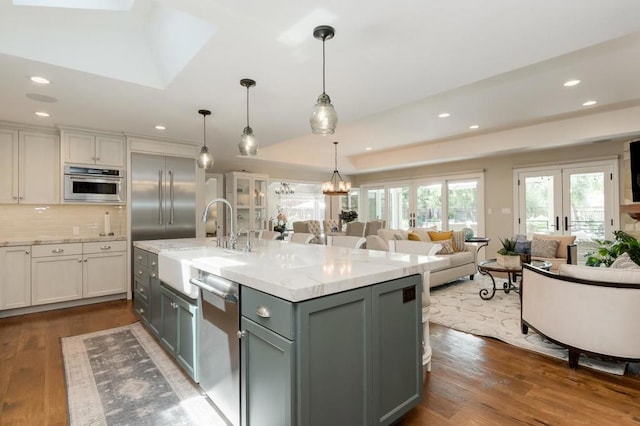 kitchen with tasteful backsplash, sink, dark hardwood / wood-style flooring, stainless steel appliances, and pendant lighting