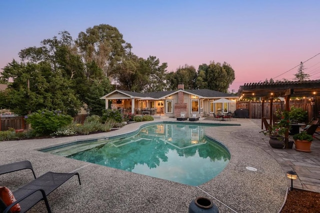 pool at dusk with a patio area