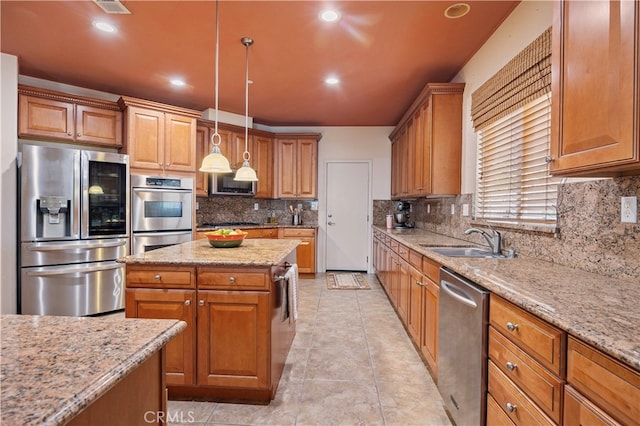 kitchen with tasteful backsplash, appliances with stainless steel finishes, sink, decorative light fixtures, and light stone counters