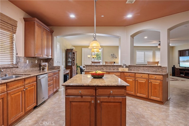 kitchen with sink, a center island, dishwasher, and hanging light fixtures